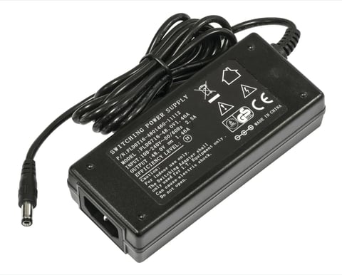 Black power adapter with coiled cable and regulatory markings on housing