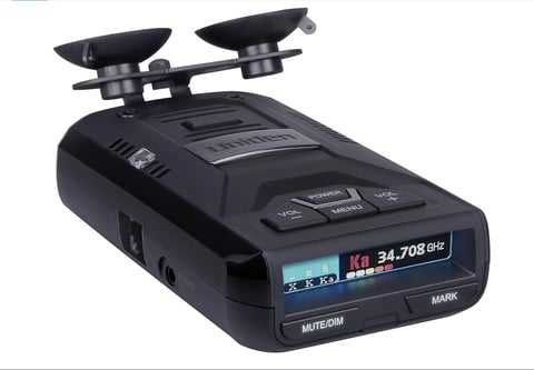 Black radar detector with dual antennas on top and digital display showing frequency reading