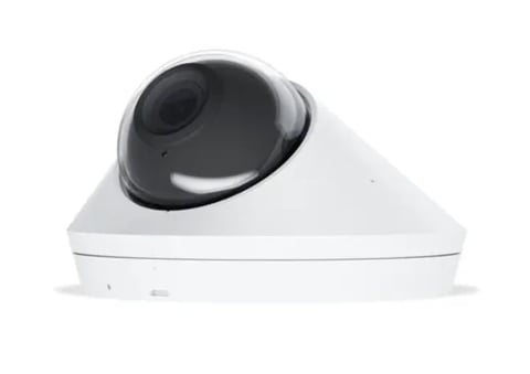 White dome security camera with black lens mounted on ceiling or wall