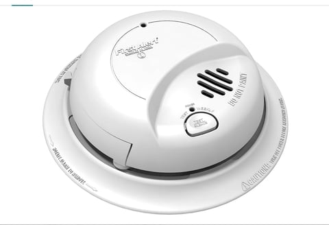 White ceiling-mounted smoke detector with test button and speaker grille