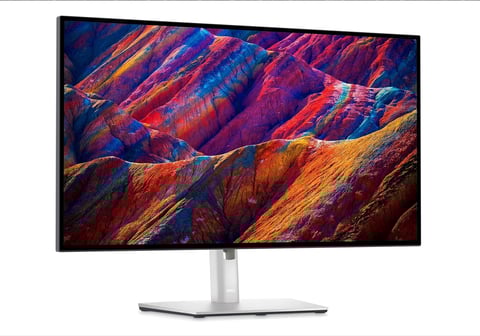Monitor displaying vibrant, colorful mountain landscape with diagonal ridges in reds, blues, oranges, and purples