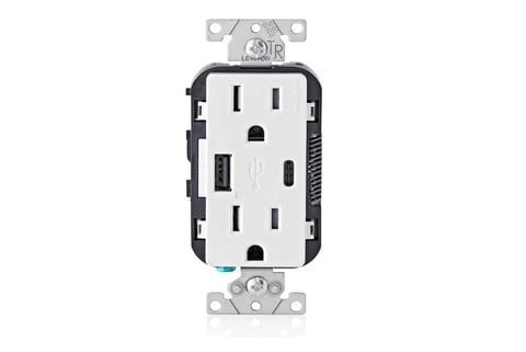 White combination electrical outlet with USB charging ports and standard outlets mounted on wall plate