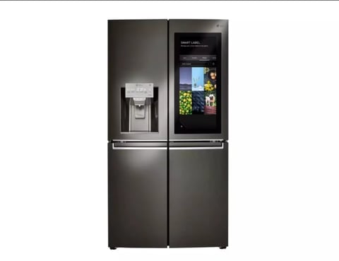Black stainless steel smart refrigerator with ice dispenser and digital display screen showing apps and food contents