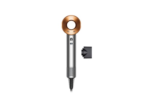 Dyson Supersonic hair dryer with rose gold top, silver body, and included concentrator nozzle attachment