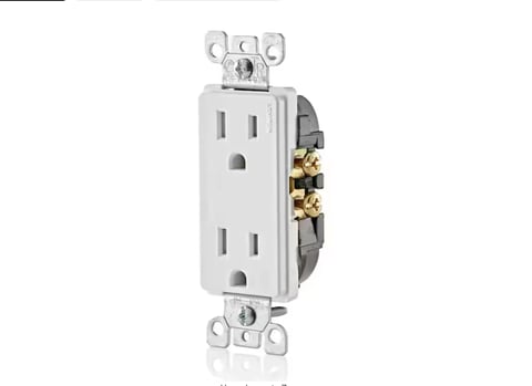 White duplex electrical outlet with two receptacles and brass terminal screws mounted on a gray backing plate