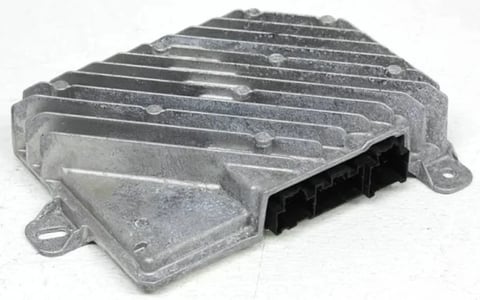 Silver metallic engine control module with finned cooling design and black electrical connector